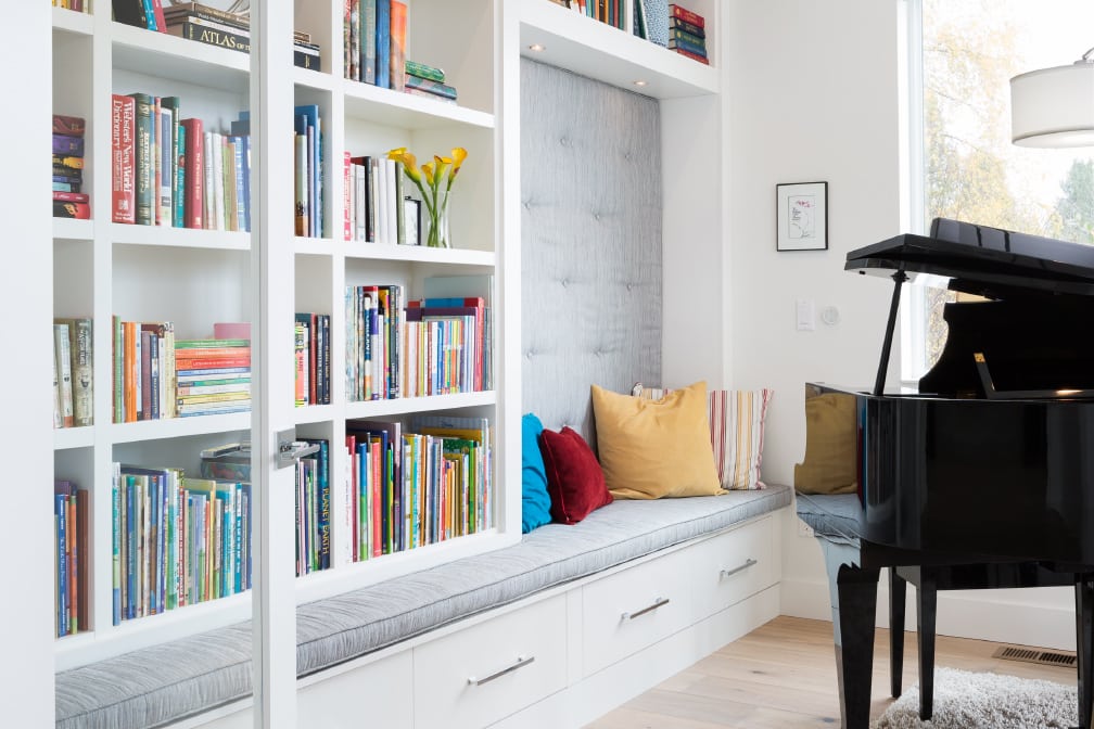 Wall-mounted library shelving with a built-in reading nook