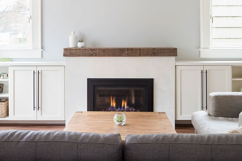 Gas fireplace with reclaimed wood mantle and built-in cabinets surrounding